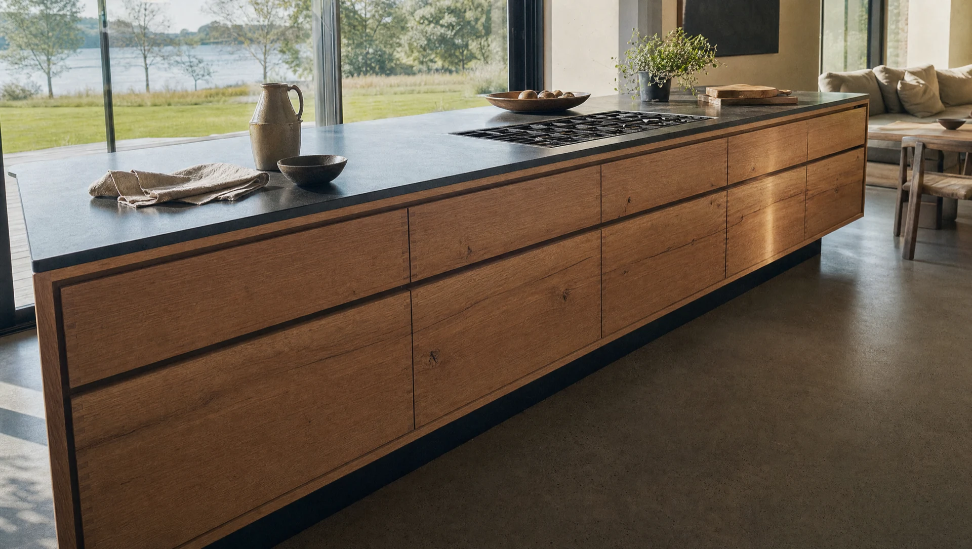 A run of brushed oak drawer fronts along the island, under a dark countertop