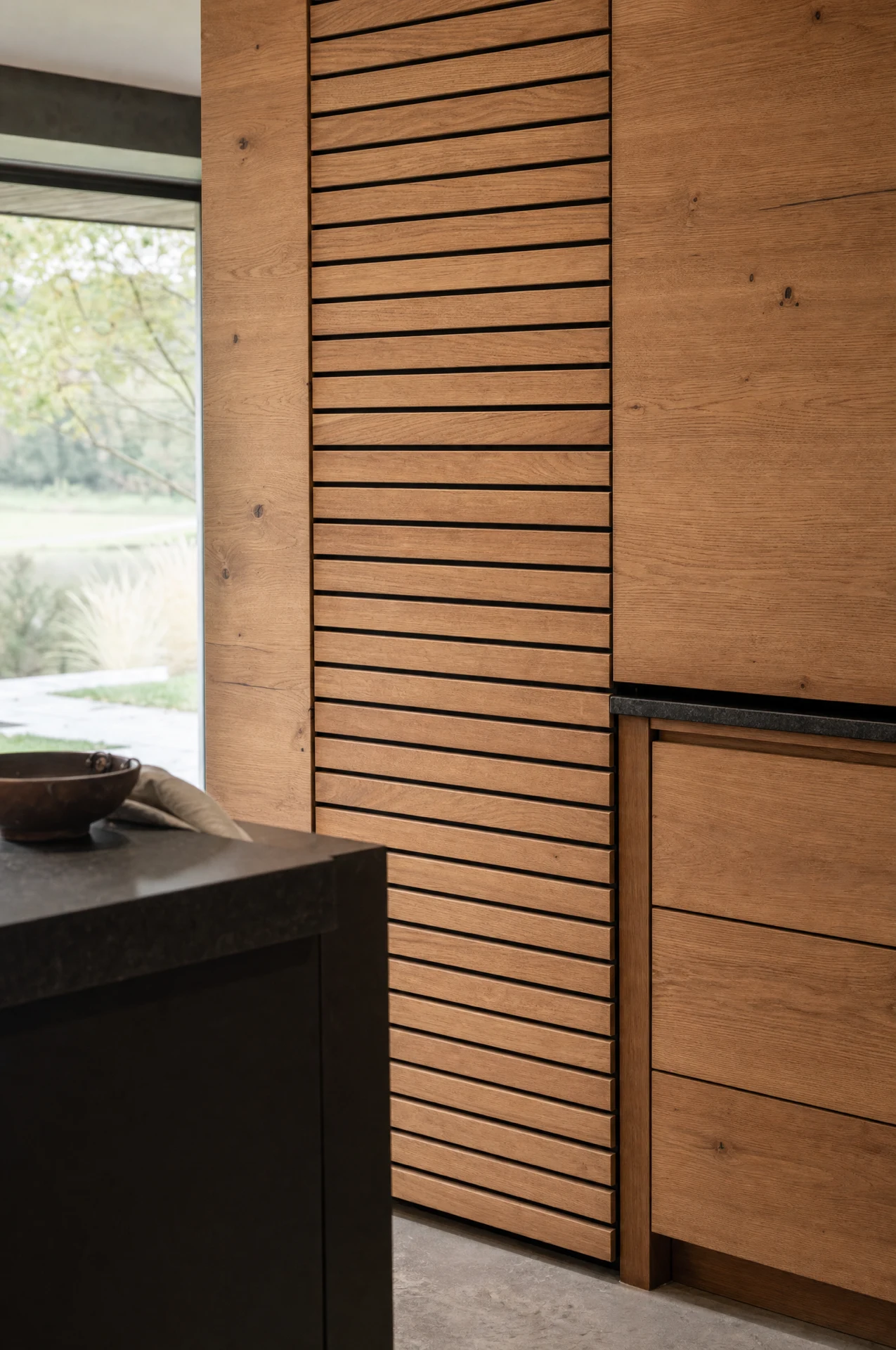 Built-in ovens in the dark run, with the patinated panel above them